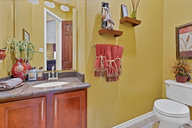 bathroom with vanity, tile patterned flooring, and toilet