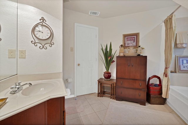 full bath featuring tile patterned floors, visible vents, two vanities, and a sink