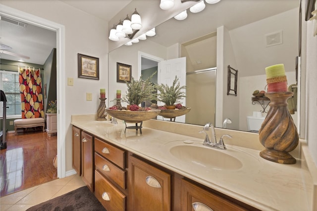 bathroom featuring double vanity, visible vents, an enclosed shower, tile patterned flooring, and a sink