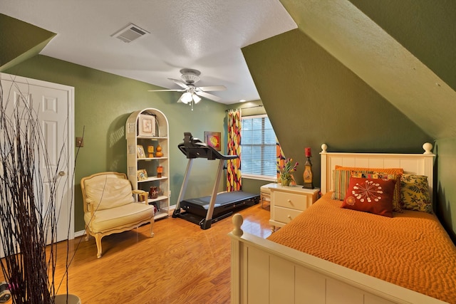 bedroom featuring light wood-style floors, a ceiling fan, and visible vents