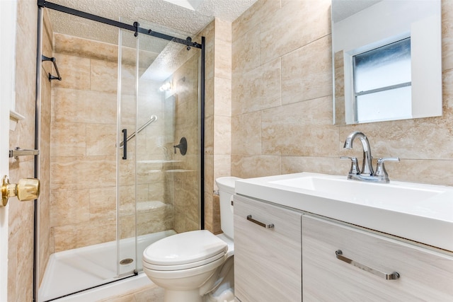 bathroom featuring vanity, toilet, tile walls, a textured ceiling, and a shower stall