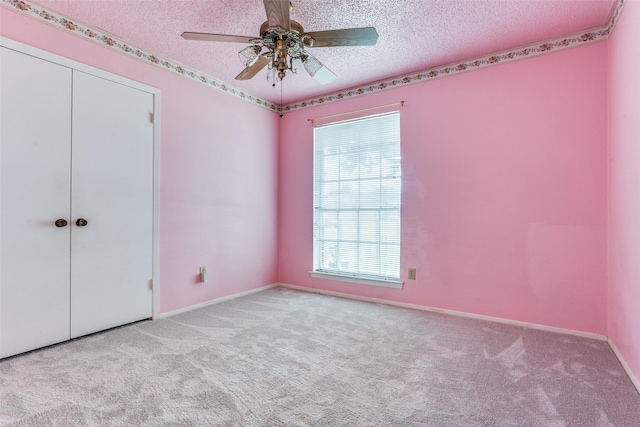 unfurnished bedroom featuring carpet floors, a textured ceiling, baseboards, and a closet