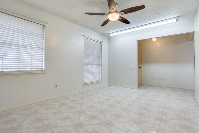 unfurnished room with a ceiling fan and a textured ceiling