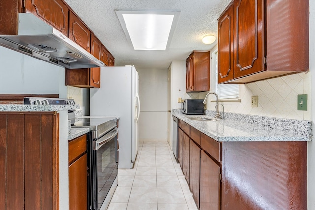 kitchen featuring a sink, stainless steel appliances, backsplash, light tile patterned floors, and under cabinet range hood