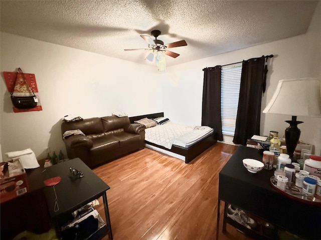 919 S Weatherred Dr Unit 211, Richardson, TX 75080 - bedroom featuring wood finished floors, a textured ceiling, and a ceiling fan