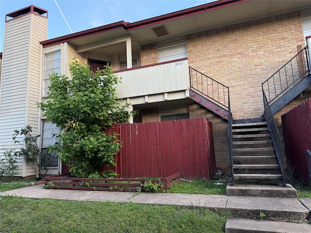 919 S Weatherred Dr Unit 211, Richardson, TX 75080 - view of property exterior with stairs, brick siding, and fence