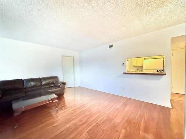 919 S Weatherred Dr Unit 211, Richardson, TX 75080 - living room featuring wood finished floors and a textured ceiling