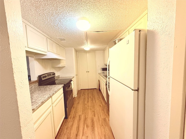 919 S Weatherred Dr Unit 211, Richardson, TX 75080 - kitchen with stainless steel electric range oven, freestanding refrigerator, a textured ceiling, light wood-style flooring, and light countertops