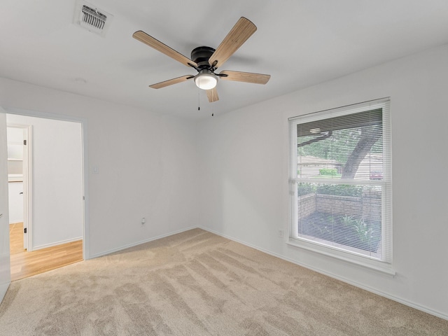 empty room featuring baseboards, carpet, a ceiling fan, and visible vents