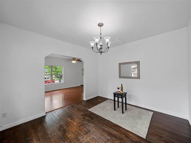 unfurnished dining area featuring wood-type flooring, baseboards, and ceiling fan with notable chandelier