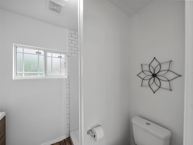 bathroom with vanity, toilet, wood finished floors, and visible vents