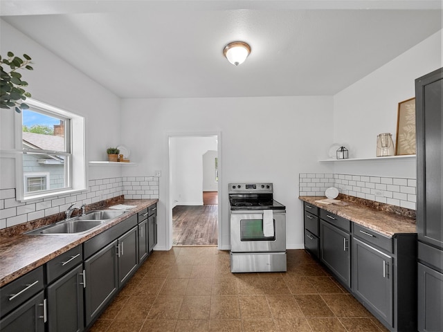 kitchen featuring decorative backsplash, open shelves, stainless steel range with electric stovetop, a sink, and baseboards