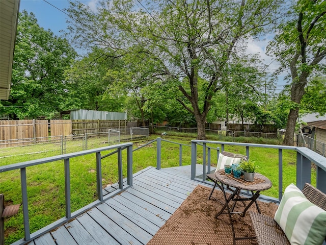 wooden deck featuring a fenced backyard and a yard