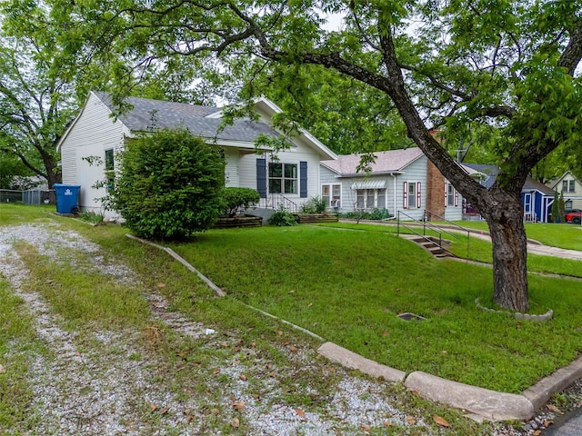 ranch-style home featuring roof with shingles and a front yard