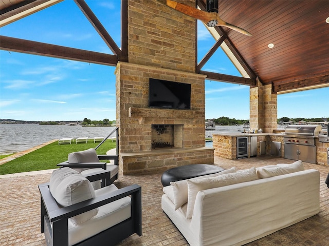 1018 Chaparrel Ln, Graford, TX 76449 - view of patio with exterior kitchen, an outdoor living space with a fireplace, a water view, area for grilling, and beverage cooler
