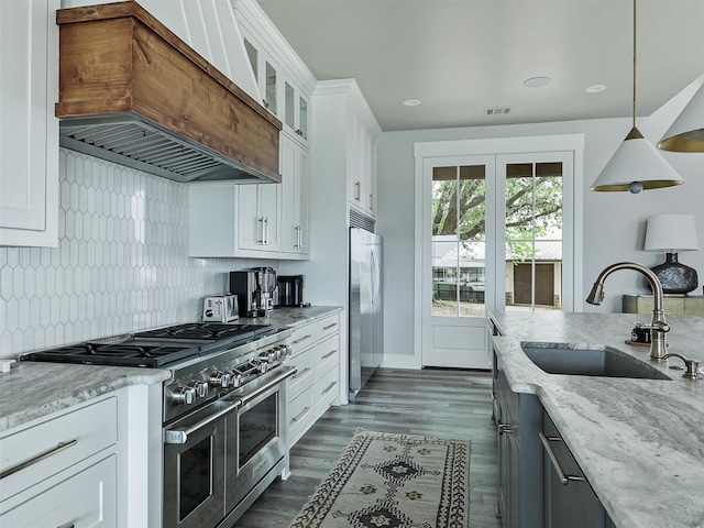 1018 Chaparrel Ln, Graford, TX 76449 - kitchen featuring high quality appliances, custom exhaust hood, a sink, light stone counters, and glass insert cabinets
