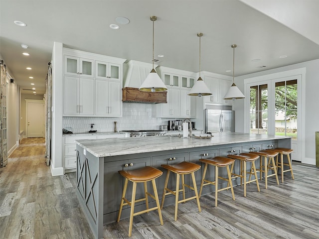 1018 Chaparrel Ln, Graford, TX 76449 - kitchen with premium range hood, stainless steel built in fridge, a large island, backsplash, and white cabinets