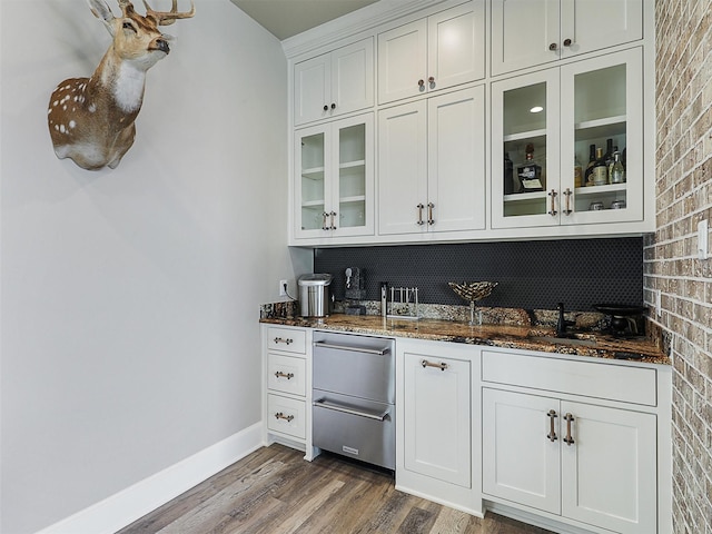 1018 Chaparrel Ln, Graford, TX 76449 - indoor wet bar with backsplash, wood finished floors, baseboards, and stainless steel dishwasher