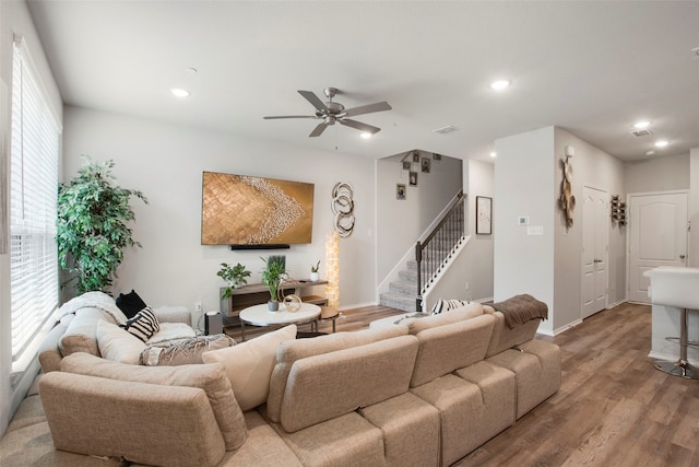 living room featuring ceiling fan, visible vents, wood finished floors, stairway, and recessed lighting