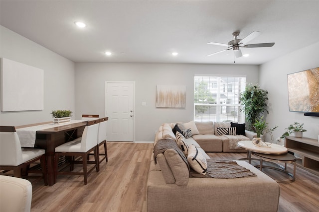 living room with light wood-style floors, a ceiling fan, baseboards, and recessed lighting