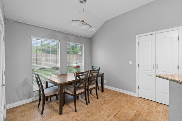 dining room featuring baseboards, vaulted ceiling, and light wood-style flooring