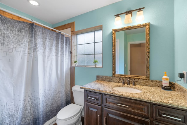 bathroom with vanity, curtained shower, and toilet