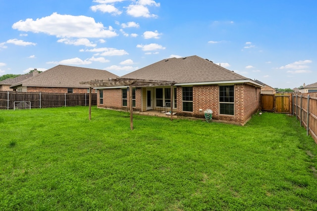 back of house with a yard, brick siding, a shingled roof, and a fenced backyard