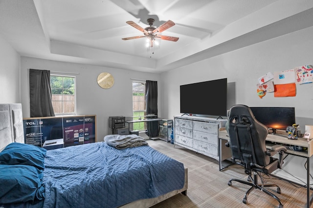 bedroom featuring a raised ceiling and ceiling fan