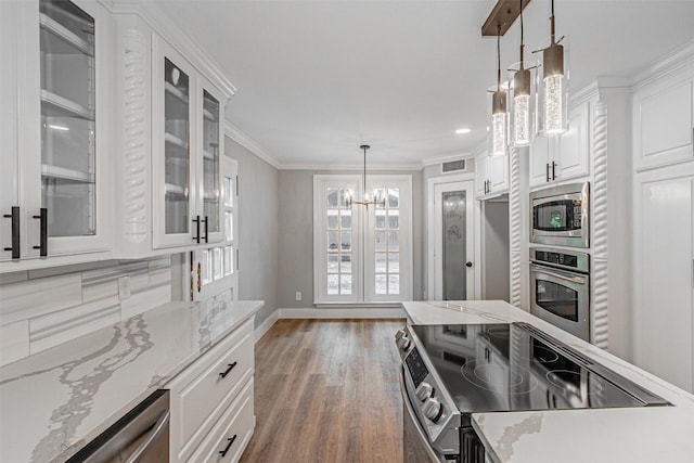 1603 Hawthorne Dr, Arlington, TX 76012 - kitchen featuring appliances with stainless steel finishes, an inviting chandelier, white cabinetry, wood finished floors, and glass insert cabinets