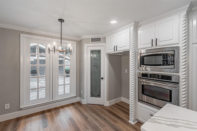 1603 Hawthorne Dr, Arlington, TX 76012 - kitchen featuring visible vents, baseboards, white cabinets, appliances with stainless steel finishes, and a notable chandelier