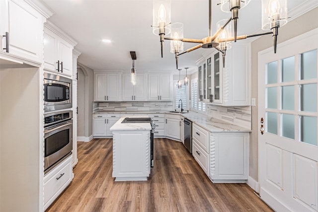 1603 Hawthorne Dr, Arlington, TX 76012 - kitchen featuring white cabinets, a notable chandelier, appliances with stainless steel finishes, and decorative backsplash