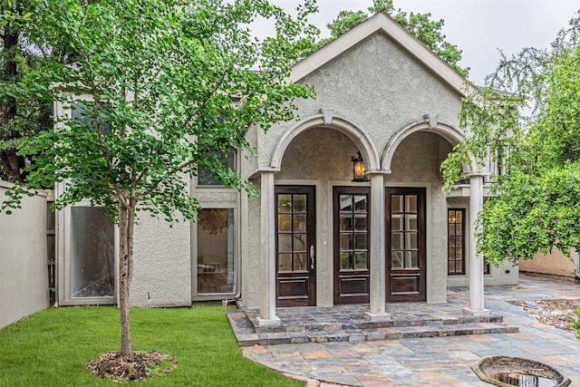 1603 Hawthorne Dr, Arlington, TX 76012 - view of exterior entry featuring stucco siding and a yard