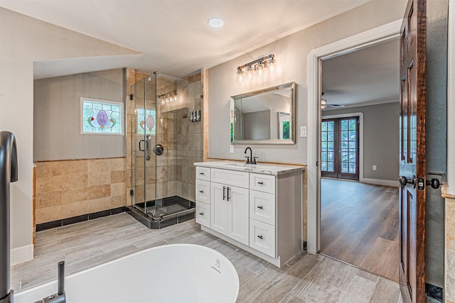 1603 Hawthorne Dr, Arlington, TX 76012 - full bath with vanity, wood finished floors, ceiling fan, a freestanding bath, and a stall shower