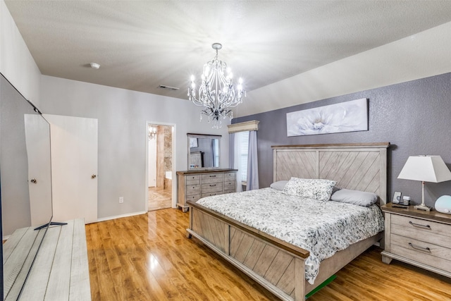 9813 Jericho Ln, Fort Worth, TX 76108 - bedroom with light wood-style flooring, a chandelier, a textured wall, ensuite bathroom, and baseboards