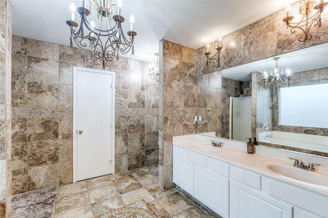 9813 Jericho Ln, Fort Worth, TX 76108 - bathroom with a chandelier, a bath, a tile shower, tile walls, and double vanity