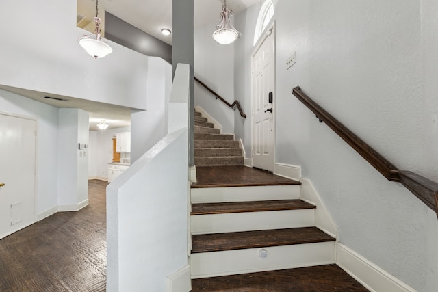 staircase featuring visible vents, baseboards, and wood finished floors