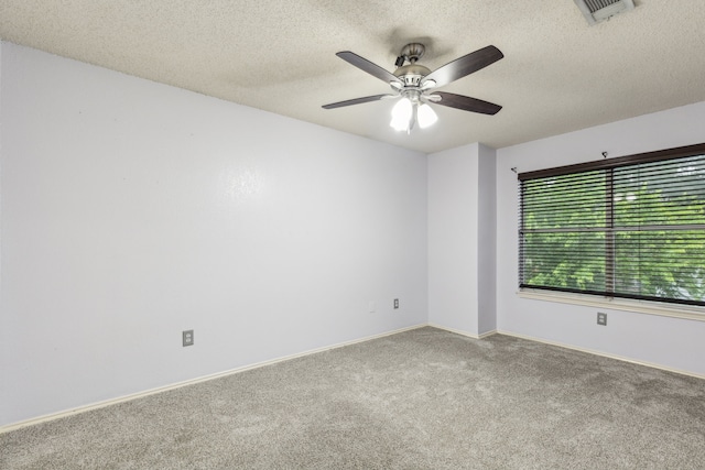 carpeted empty room featuring baseboards, a ceiling fan, a textured ceiling, and visible vents