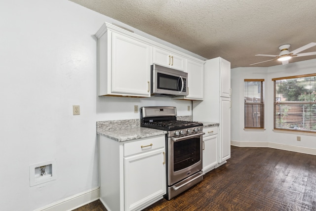 kitchen featuring a ceiling fan, a textured ceiling, baseboards, stainless steel appliances, and white cabinetry