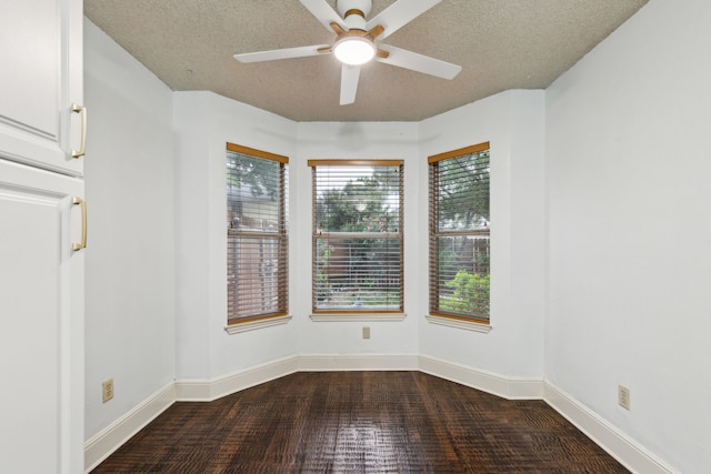 empty room with baseboards, a ceiling fan, a textured ceiling, and wood finished floors