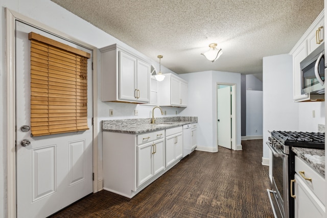 kitchen featuring a sink, dark wood finished floors, appliances with stainless steel finishes, and white cabinets