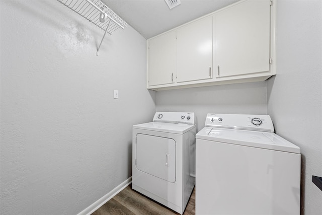 washroom featuring independent washer and dryer, visible vents, dark wood finished floors, cabinet space, and baseboards