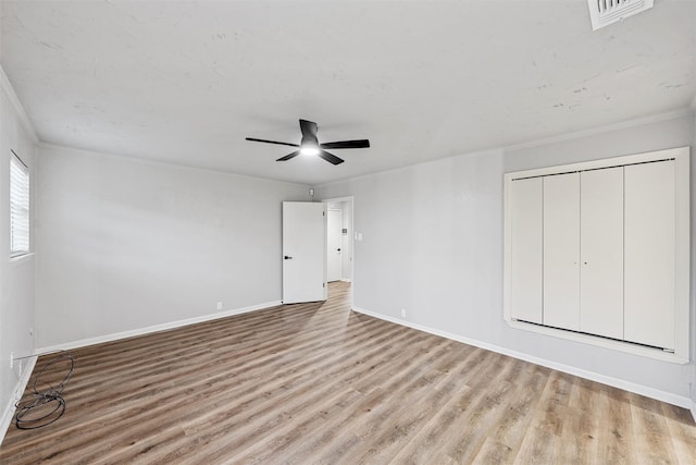 unfurnished bedroom with baseboards, ornamental molding, and wood finished floors