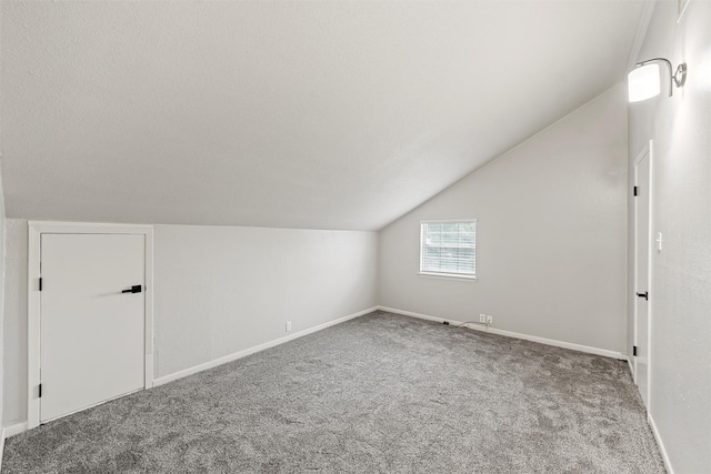 additional living space featuring baseboards, carpet flooring, and lofted ceiling