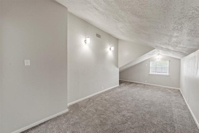 bonus room featuring vaulted ceiling, carpet flooring, and a textured ceiling