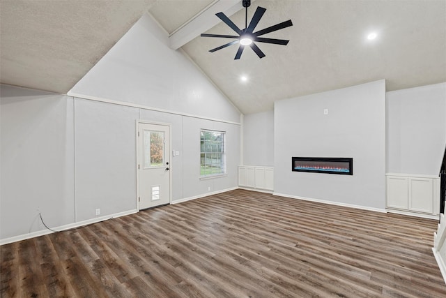unfurnished living room with a ceiling fan, wood finished floors, high vaulted ceiling, beamed ceiling, and a glass covered fireplace