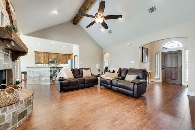 living area featuring visible vents, beam ceiling, ceiling fan, high vaulted ceiling, and arched walkways