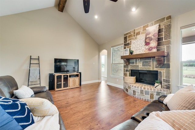 living room featuring arched walkways, high vaulted ceiling, a ceiling fan, wood finished floors, and beamed ceiling