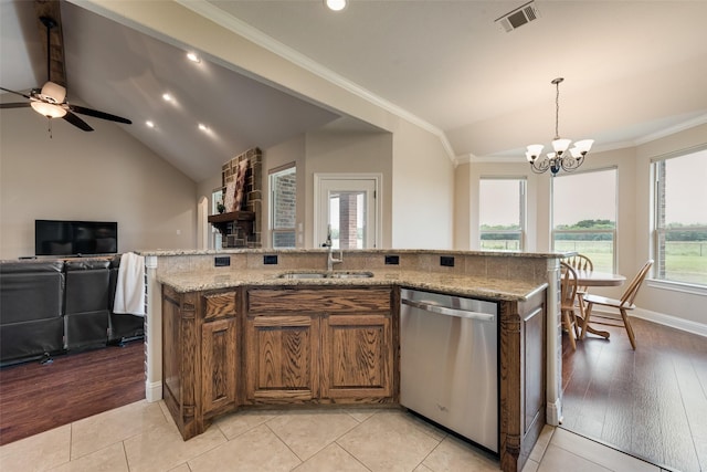 kitchen featuring stainless steel dishwasher, visible vents, lofted ceiling, brown cabinets, and a sink