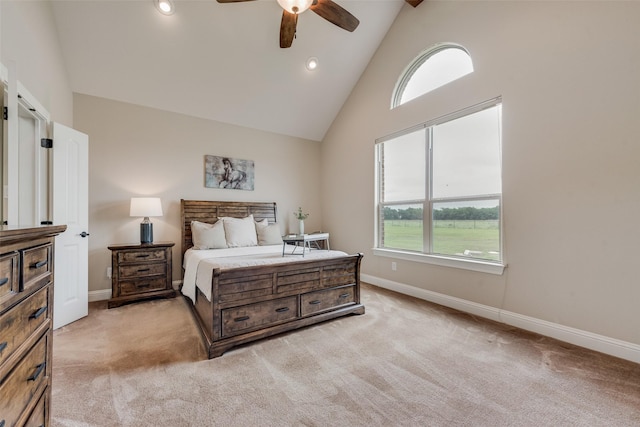 bedroom featuring baseboards, multiple windows, light carpet, and high vaulted ceiling
