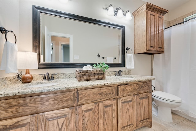 bathroom with tile patterned flooring, double vanity, a sink, and toilet